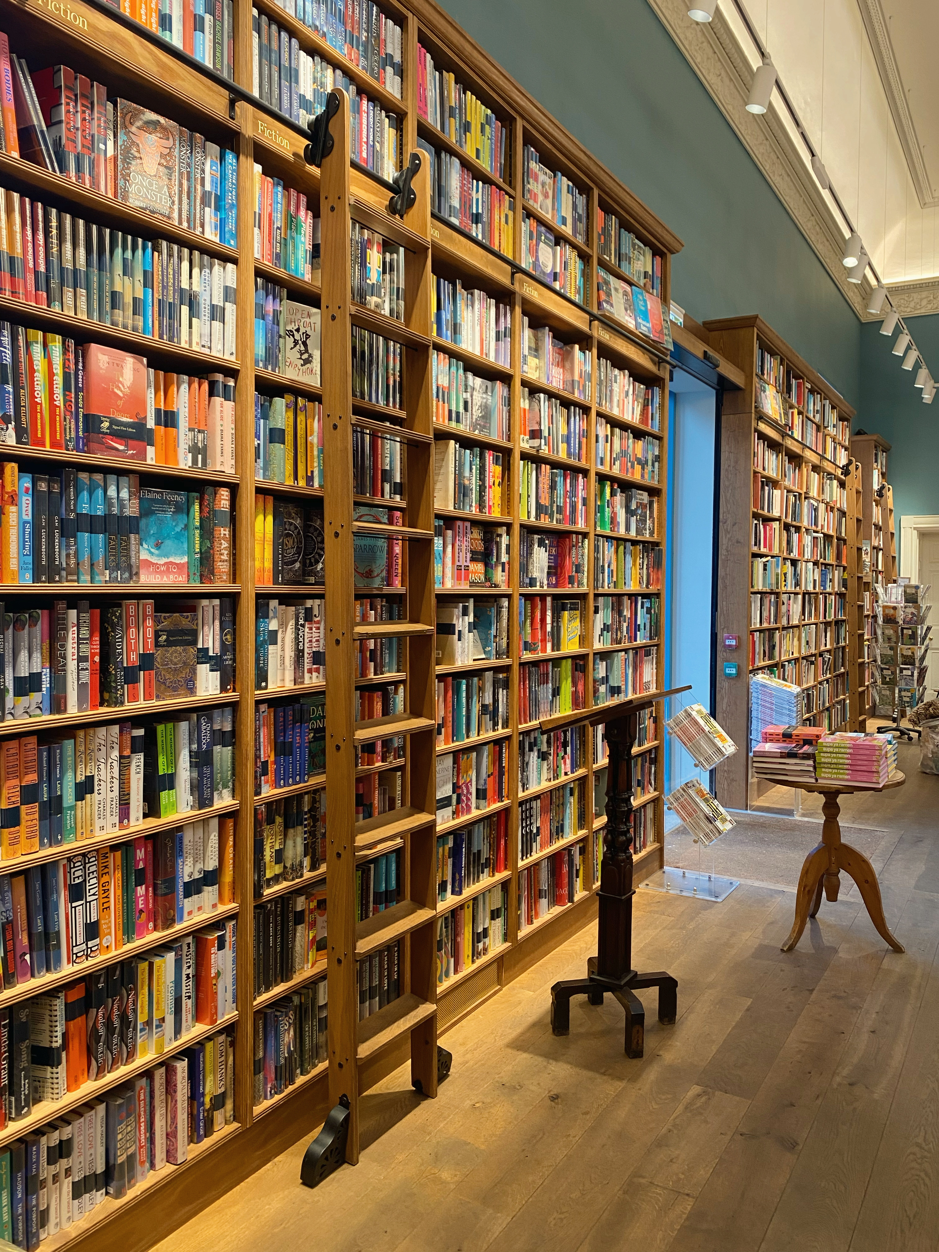 A bookshop with tall shelves filled with books and ladders.