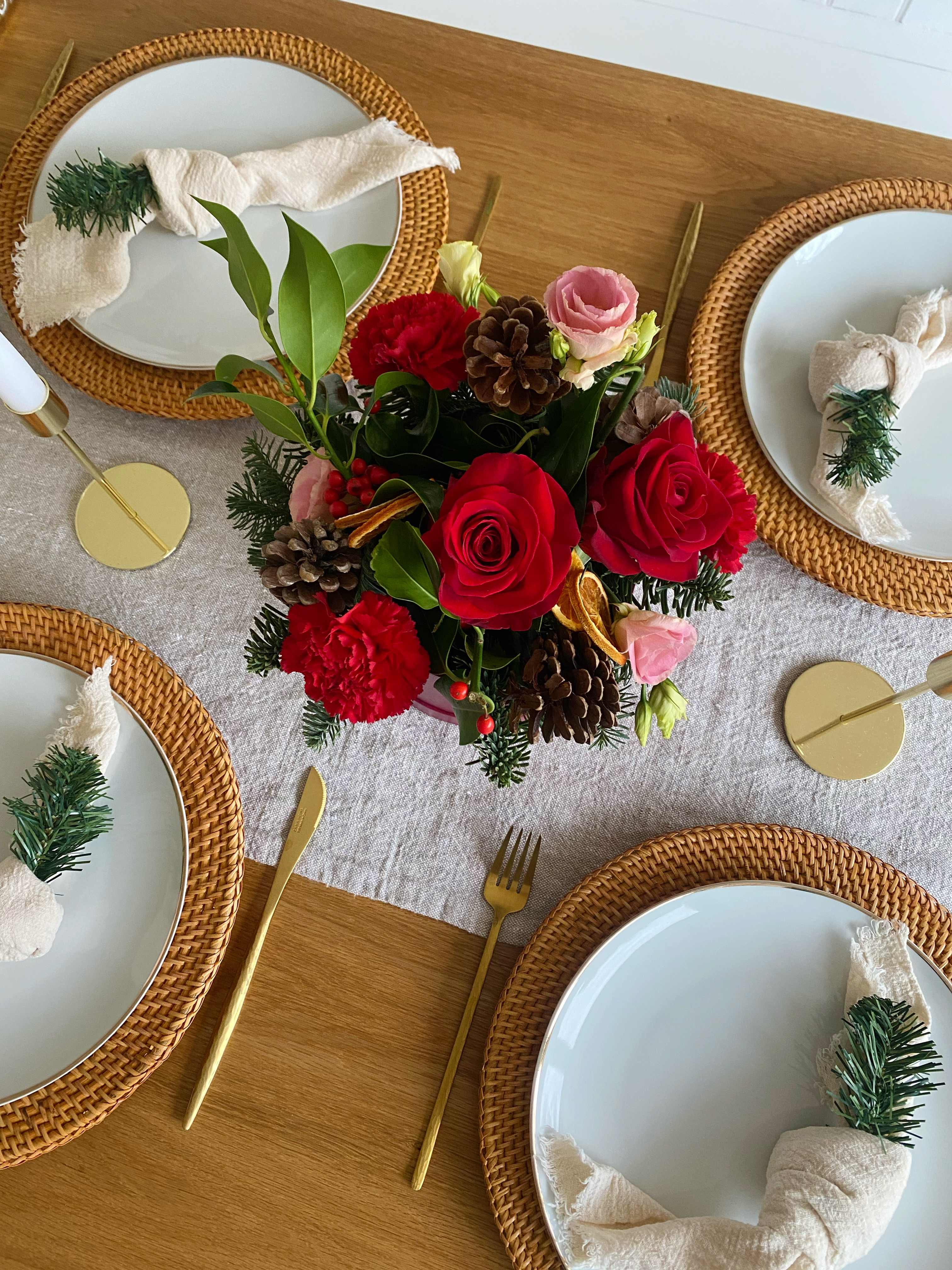 A bunch of red Christmas flowers on a decorated dining table.